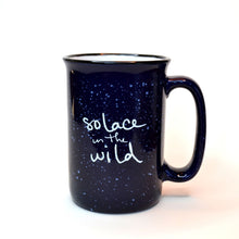 Load image into Gallery viewer, Blue ceramic Solace in the Wild mug with white writing and white speckles.